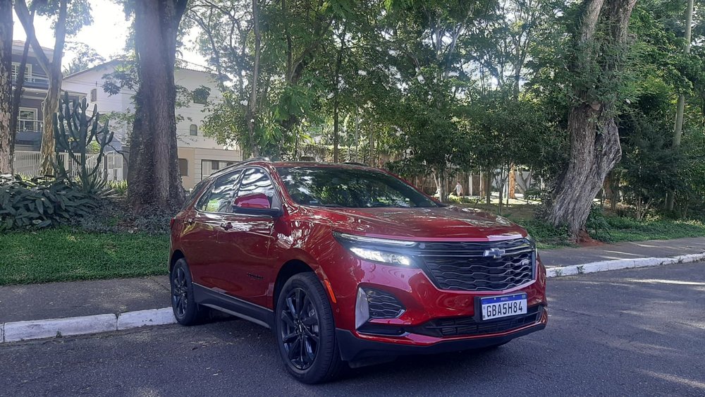 Foto: Sérgio Dias)</em></p>
<p>[image,146888] <em>(Foto: Sérgio Dias)</em></p>
<p>Com exclusividade, o Chevrolet Equinox RS conta com cromados escurecidos, assim como as rodas, o rack de teto e o logo Chevrolet. Há também itens únicos na versão, como a grade frontal e outros elementos dos para-choques. No habitáculo, teto preto e a as linhas vermelhas que decoram bancos, volante, alavanca de câmbio e painéis são próprias da versão RS.</p>
<p>A versão ainda conta com atualizações remotas de sistemas eletrônicos, myChevrolet App, MyLink com projeção sem fio para Android Auto e Apple Car Play, Wi-Fi nativo, Spotify e Alexa, além do conhecido sistema OnStar, sistema de telemática avançado da GM que oferece assistência personalizada 24 horas por dia/7 dias por semana para serviços de emergência e segurança.</p>
<p>[image,146887] <em>(Foto: Sérgio Dias)</em></p>
<p>Sua ampla lista de itens de comodidade e de segurança incluem alerta de colisão frontal com detecção de pedestre e frenagem autônoma de emergência, alerta de ponto cego com sensor de aproximação repentina, alerta de movimentação traseira, alerta vibratório de segurança no banco do motorista e alerta de esquecimento de pessoas ou objetos no banco traseiro.</p>
<p>Mais uma novidade que estreia com o SUV da Chevrolet é a adoção da inteligência artificial Alexa que já opera smart home. Com isso, o usuário do veículo pode pedir para Alexa tocar músicas, fazer consultas diversas, obter direções, adicionar itens à sua lista de compras, controlar dispositivos de smart home e muito mais, apenas com a voz.</p>
<p>[image,146889] <em>(Foto: Sérgio Dias)</em></p>
<p>O aplicativo myChevrolet para smartphone e smartwatch permite comandar funções do carro a distância, fazer diagnósticos remotos, consultas técnicas e agendar serviços na rede autorizada.</p>
<p>Um dos diferenciais do modelo frente aos principais concorrentes são suas dimensões: 4.652 mm de comprimento, 2.725 mm de entre-eixos, 2.105 mm de largura e 1.843 mm de altura e porta-malas com 468 litros, podendo chegar a 1.627 litros com os bancos rebatidos.</p>
<p>[image,146890] <em>(Foto: Sérgio Dias)</em></p>
<p>Por falar em concorrentes, a linha Chevrolet Equinox tem potencial para melhorar seus resultados comerciais. No segmento dos SUVs médios, ocupa apenas a 11ª posição, com 3,7 mil unidades emplacadas até o mês de novembro de 2023.</p>
<p>Para ficar apenas nos dois primeiros mais vendidos até novembro no segmento dos SUVs médios, o Jeep Compass teve 55,2 mil e o Toyota Corolla Cross 37,7 mil unidades emplacadas. Muita diferença para veículos que têm potenciais parecidos – embora apenas o Chevrolet Equinox seja importado.</p>
<p>[image,146890] <em>(Foto: Sérgio Dias)</em></p>
<p>[image,146891] <em>(Foto: Sérgio Dias