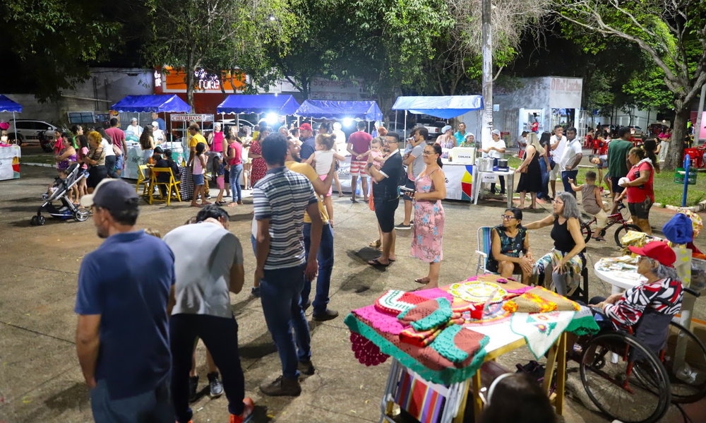 Foto: Marcos Filho Sandes)</em></p>
<p><strong>Mais perto do povo</strong></p>
<p>A feira, que tradicionalmente era realizada na Praça das Nações, terá um diferencial. “A cada 15 dias, ela será realizada em um local diferente. Esse formato itinerante vem para aproximar o evento de quem mora nos bairros. Em breve vamos divulgar o cronograma das exposições para a população poder prestigiar”, explicou o secretário da Cultura, Edson Gallo.</p>
<p>Para os artesãos, além de movimentar as vendas, a feira é uma oportunidade de tornar seu trabalho conhecido. “Trabalho com vendas desde antes da pandemia. Quando a feira foi suspensa, comecei a expor meus produtos nas redes sociais. Mas o contato com o público e a interação física fazem toda a diferença”, comentou Shirley Sousa, que produz tiaras, laços e outros acessórios femininos.</p>
<p>Embora não more próximo do setor Noroeste, a chef de cozinha Suzi Sousa, que é sobrinha de Shirley, fez questão de visitar a feira com o esposo Jardel e a filha Helena. “Viemos prestigiar minha tia e aproveitar o finalzinho de domingo curtindo esse espaço”, afirmou.</p>
<p><!-- out NEWS_1 empty --></p>
<p>A vendedora de doces e salgados, Leide Oliveira, conta que iniciou na feira ainda na década de 1990, acompanhando a mãe, Regina. “Devido à idade, ela agora optou por não vir, mas nós seguimos com trabalho que ela iniciou. É uma boa vitrine, as pessoas vêm conhecer nossos produtos e pegam nosso contato para fazer encomendas”, disse.</p>
<p>[image,148580] <em>(Foto: Marcos Filho Sandes